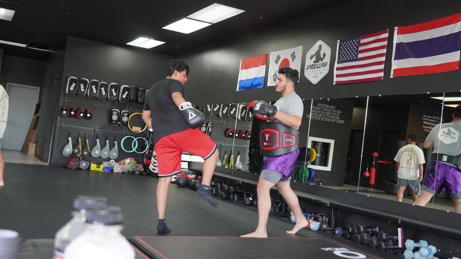 Adult Muay Thai student practicing knee strikes on pads at Embellish Kickboxing Academy in Elk Grove.